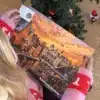 Kvinde i julesweater der åbner en låge i Aabenraakalenderen under juletræet