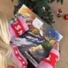 Kvinde i julesweater der åbner en låge i Køgekalenderen under juletræet
