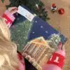 Kvinde i julesweater der åbner en låge i Koldingkalenderen under juletræet