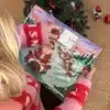 Kvinde i julesweater der åbner en låge i Odensekalenderen under juletræet