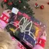 Kvinde i julesweater der åbner en låge i Ringstedkalenderen under juletræet