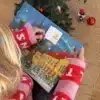 Kvinde i julesweater der åbner en låge i Roskildekalenderen under juletræet