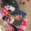 Kvinde i julesweater der åbner en låge i Svendborgkalenderen under juletræet