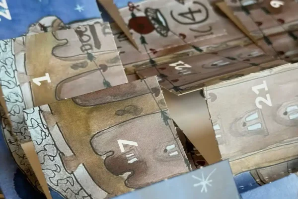 Bykalender julekalender 2025 i julesetting med kalenderlåger og julepynt